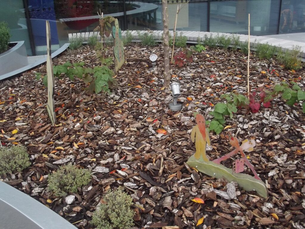 Bacs de culture alignés sur un balcon étroit, tomates tuteurées et larges feuilles de blette