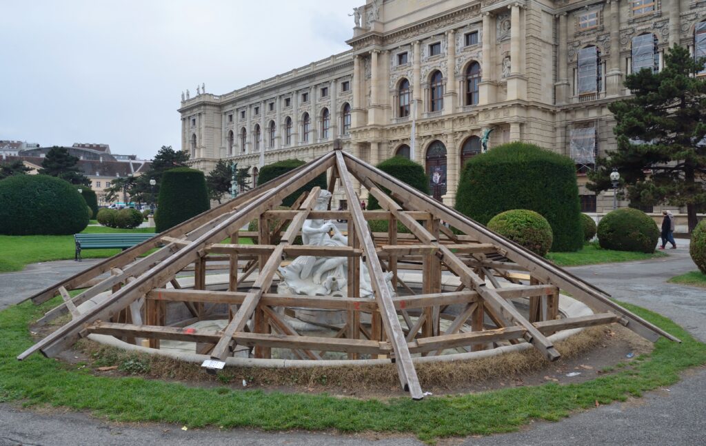 Voile d'hivernage blanc noué autour d'un pot, feuillage protégé sous la toile par temps froid